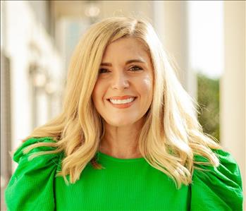 Woman with blonde hair and a green shirt 