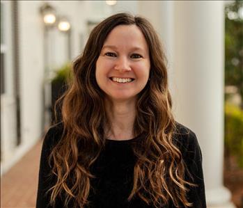 Woman with long brown hair in a black shirt 