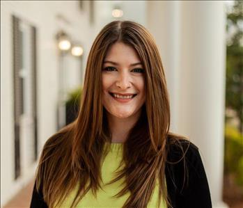 Woman with long brown hair in a green shirt 