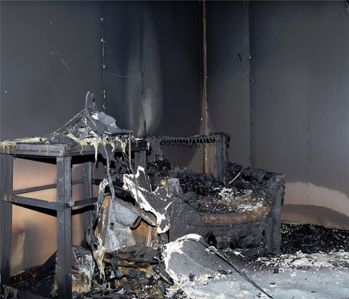 a fire damaged room with soot covering everything and debris everywhere
