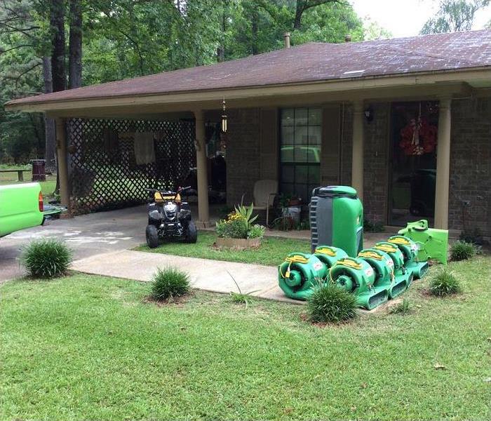 SERVPRO restoration equipment stacked outside of home