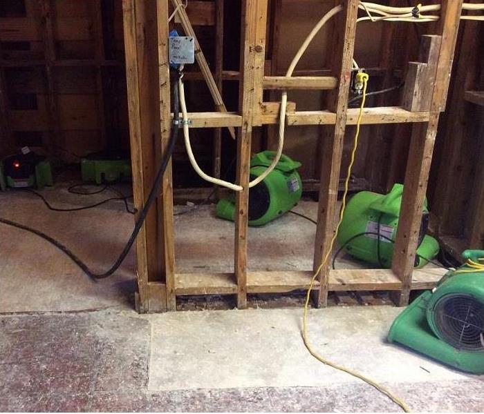 inside flood damaged home; drywall removed to studs; SERVPRO equipment seen drying room