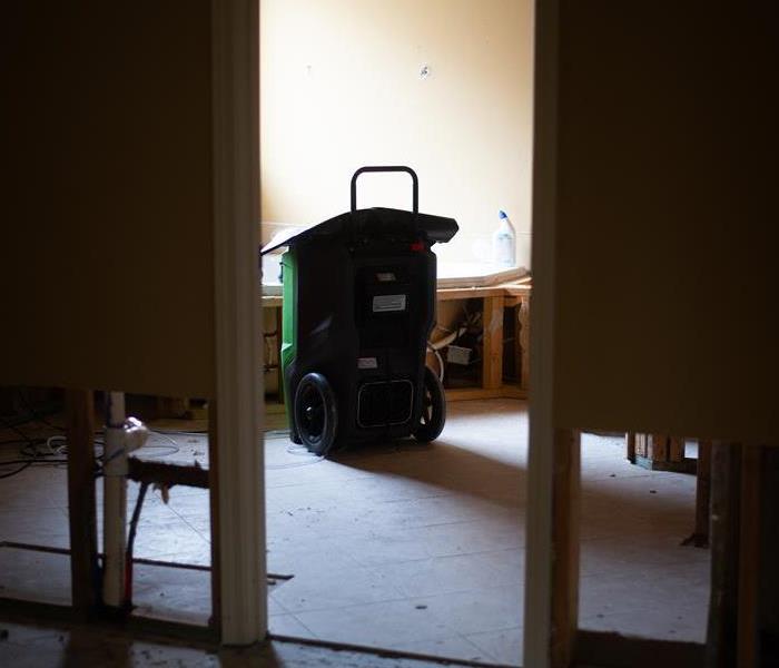 Dehumidifier sitting in water damaged bathroom