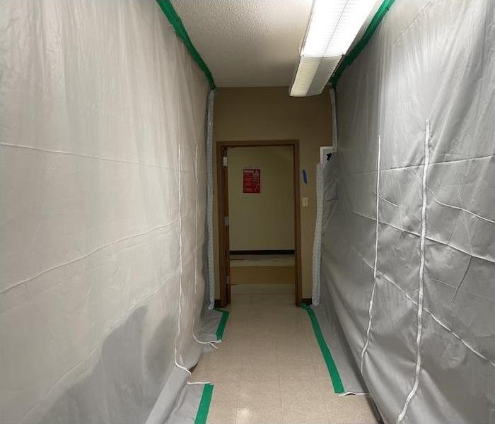 Containment barrier set up in a hallway of a school with mold damage